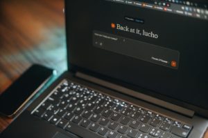Laptop screen says "back at it, lucho".