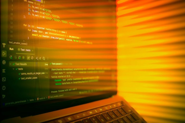 Laptop screen displaying code with orange glow.